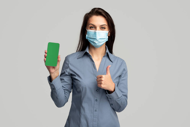 Woman in medical mask advertising smartphone app - Foto, Imagem