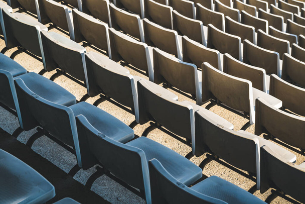 Rows of empty seats of a large outdoor stadium on a sunny day before sports event - 写真・画像