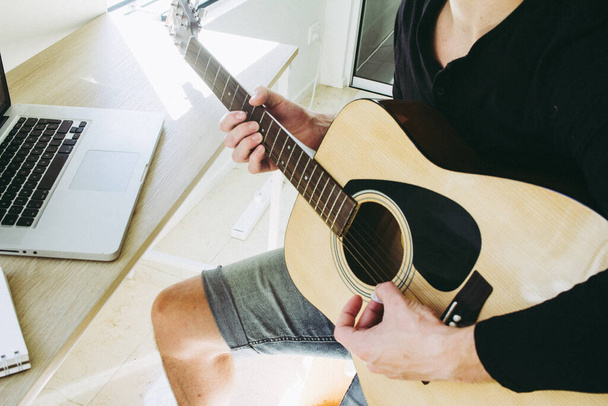 férfi tanul gitározni online segítségével laptop - Fotó, kép