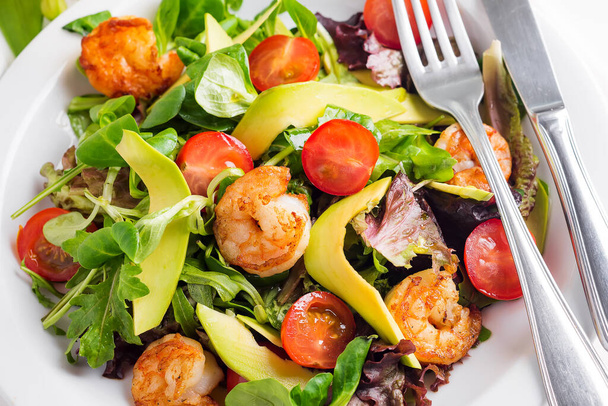 Avocado shrimp salad with cherry tomatoes and latuce salad on a plate - Foto, Bild