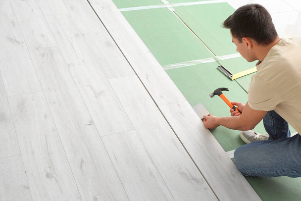 Truhlář instalující laminátové podlahy v místnosti - Fotografie, Obrázek
