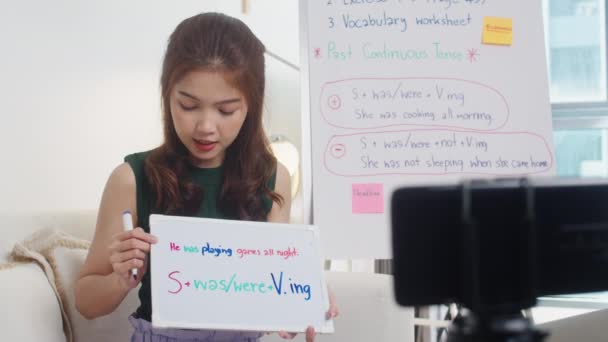 Asia joven mujer inglés profesor de videollamadas en el teléfono inteligente hablar por webcam aprender a enseñar en el chat en línea en casa. Educación remota, distanciamiento social, cuarentena para la prevención del virus corona. - Imágenes, Vídeo
