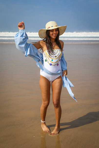 Girl on the beach in swimsuit and hat. The Atlantic Ocean Agadir Morocco. - Photo, Image