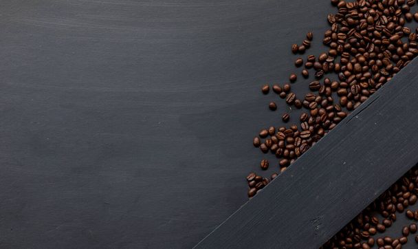 Kaffeebohne auf schwarzem Holzboden Hintergrund. Ansicht von oben. Raum für Text - Foto, Bild