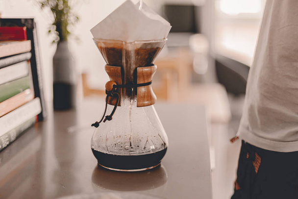Husband is making brewing fresh coffee in in the morning. Lifestyle kitchen countertop, table. Breakfast time. Meal preparation. Everyday pleasant routine. Copper kettle. Ready for work. Simple life - Foto, Imagen