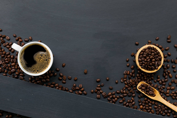 Kaffee und Bohne auf schwarzem Holztischhintergrund. Ansicht von oben - Foto, Bild