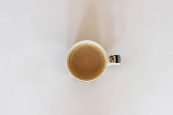 Taza de café aislada sobre fondo blanco. Gachas de café sobre un fondo blanco. Vista superior de una taza de café
 - Foto, imagen
