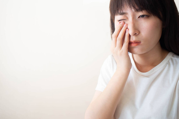 Mujer asiática que sufre de dolor en los ojos y sentir algo en los ojos. La causa del dolor incluye problema de lente de contacto, conjuntivitis, objeto extraño, síndrome de ojo seco o alergia
. - Foto, Imagen