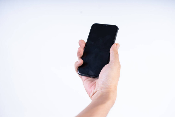 Isolierte Aufnahme der Hand eines Mannes, der ein Mobiltelefon hält, nahtloser weißer Hintergrund - Foto, Bild