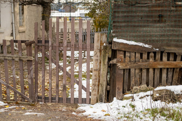 La anchura de la cerca de madera la puerta del jardín en el día frío invernal. Edificio abandonado y abandonado en una tierra desierta en Eskisehir, Turquía. Edificio exterior
. - Foto, Imagen