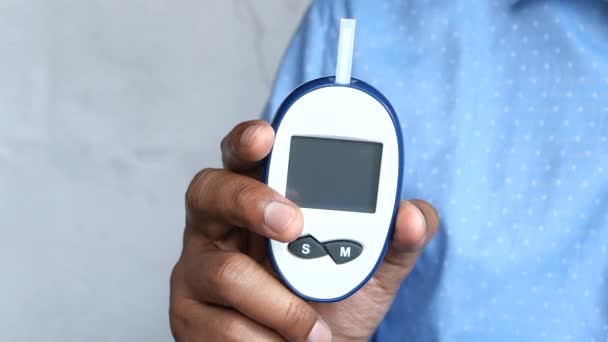 άνθρωπος χέρι μέτρηση διαβητικού επιπέδου γλυκόζης στο σπίτι  - Πλάνα, βίντεο