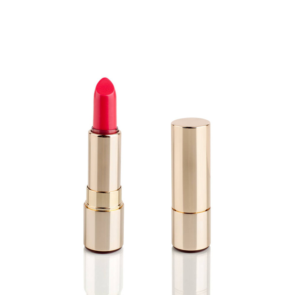 Rode lippenstift in gouden buis op witte achtergrond met spiegelreflectie op glazen oppervlak geïsoleerd close-up, glanzend gouden lippenstift pakket, open en gesloten lippenstift doos, luxe cosmetische accessoire set - Foto, afbeelding