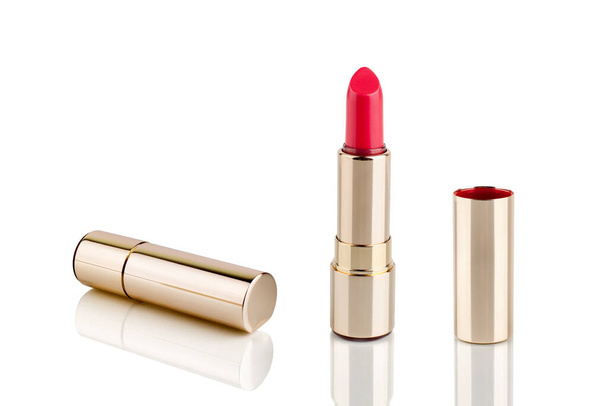 Red lipstick in golden tube on white background with mirror reflection on glass surface isolated close up, shiny gold lipstick package, open and closed lipsticks box, luxury cosmetic accessory set - Photo, Image
