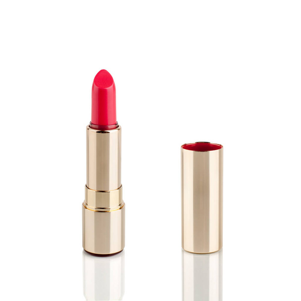 Rode lippenstift in gouden buis op witte achtergrond met spiegelreflectie op glazen oppervlak geïsoleerd close-up, open roze lippenstift in gouden verpakking, dure luxe cosmetische accessoire, studio shot - Foto, afbeelding