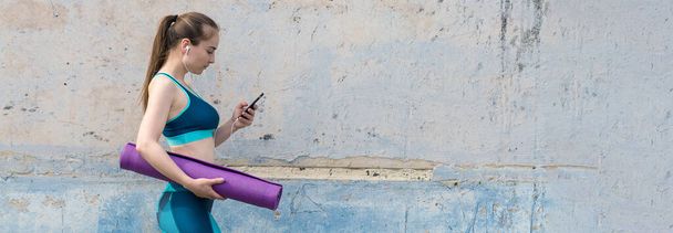 Een jong slank atletisch meisje in sportkleding met slangenhuid prints voert een reeks oefeningen uit. Fitness en gezonde levensstijl. - Foto, afbeelding