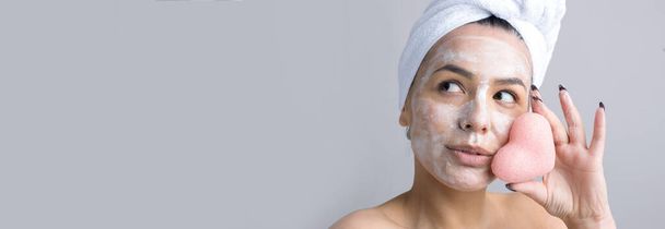 Beauty portrait of woman in white towel on head  with a sponge for a body in view of a pink heart. Skincare cleansing eco organic cosmetic spa relax concept. - Photo, Image
