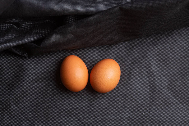 Eggs on black fabric background - 写真・画像