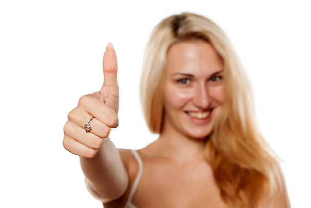 boldog fiatal szőke nő felmutatja hüvelykujját - Fotó, kép