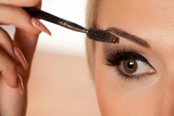 closeup of eyebrow shaping with brush - Photo, Image