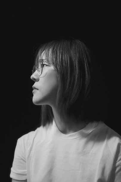 Dramatisch emotioneel portret van een Aziatisch meisje in studio, Foto in zwart-wit. - Foto, afbeelding