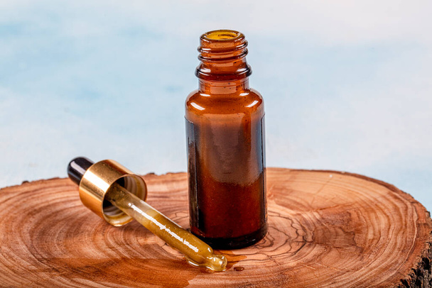 Propolis Drop Oil drop falling. A bottle of propolis on piece of wood. - Photo, Image