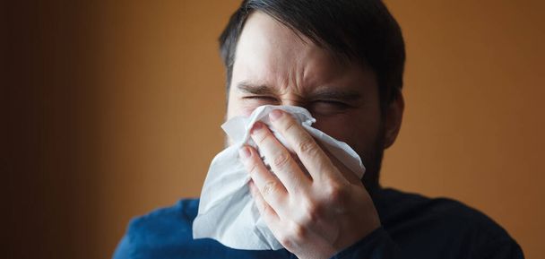 Hombre europeo estornudando violentamente en el pañuelo
 - Foto, Imagen