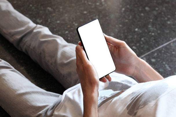 adolescente do sexo masculino segurando e mostrando telefone inteligente em branco i com caminho de recorte a exibição com espaço de cópia para o seu texto
 - Foto, Imagem