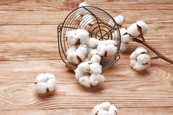 Basket with beautiful cotton flowers on wooden background - Photo, Image