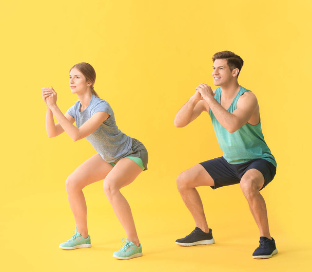 Sportliches junges Paar trainiert auf farbigem Hintergrund - Foto, Bild