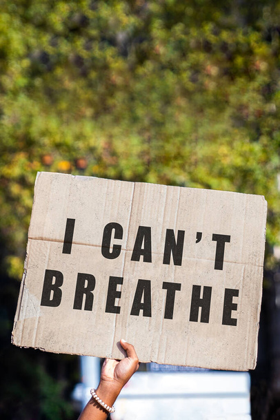 Braço de uma mulher afro-americana segurando um sinal com uma poderosa mensagem anti-racista. Não consigo respirar.
. - Foto, Imagem