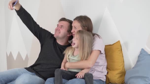 Glückliche Familie, Vater, Mutter und Tochter machen ein lustiges gemeinsames Selfie auf dem Handy - Filmmaterial, Video