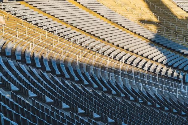 Rijen lege stoelen van een groot stadion op zonnige dag voor het sportevenement - Foto, afbeelding