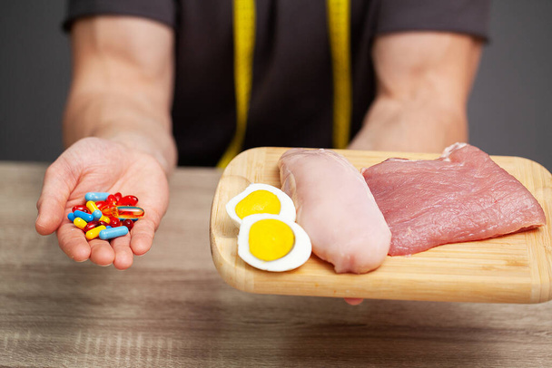 Ένας άνθρωπος κατέχει τρόφιμα με υψηλή περιεκτικότητα σε πρωτεΐνες για σωστή διατροφή - Φωτογραφία, εικόνα