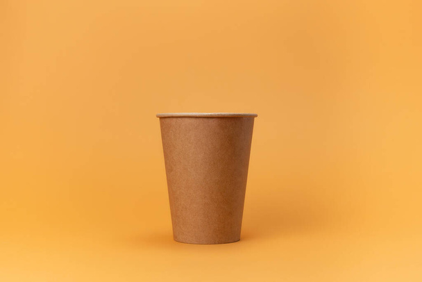χάρτινο κύπελλο μίας χρήσης για καφέ που απομονώνεται σε μπεζ φόντο - Φωτογραφία, εικόνα