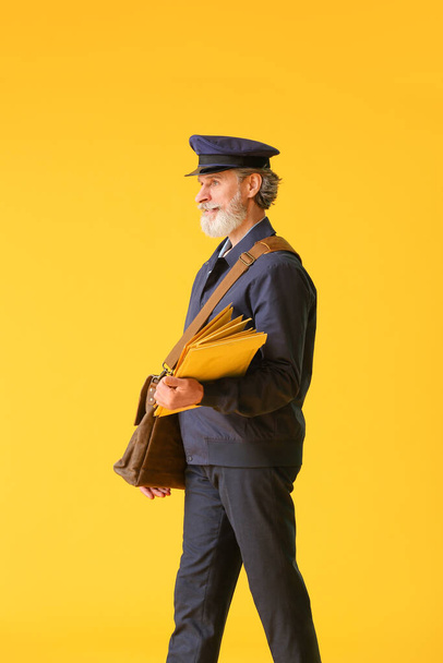 Handsome old postman on color background - Фото, зображення