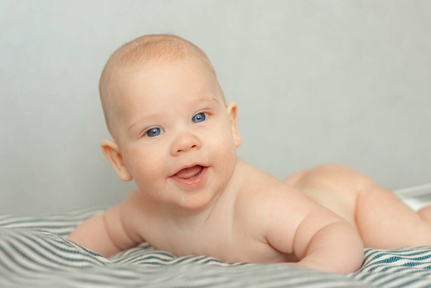 Closeup portrait of beautiful baby boy with blue eyes looking straight in camera - Foto, imagen