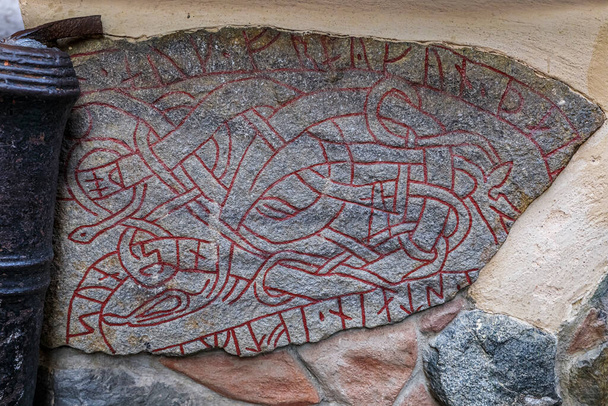 İsveç 'in Stockholm kentindeki Gamla Stan Eski Kasabası' nda bir duvara inşa edilmiş antik bir Viking rününün parçası. - Fotoğraf, Görsel