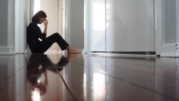 Smutná dospělá osamělá žena sedí na temné domácí chodbě podlahy. - Záběry, video