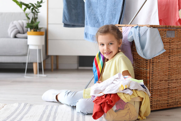 Kleines Mädchen mit schmutziger Wäsche zu Hause - Foto, Bild