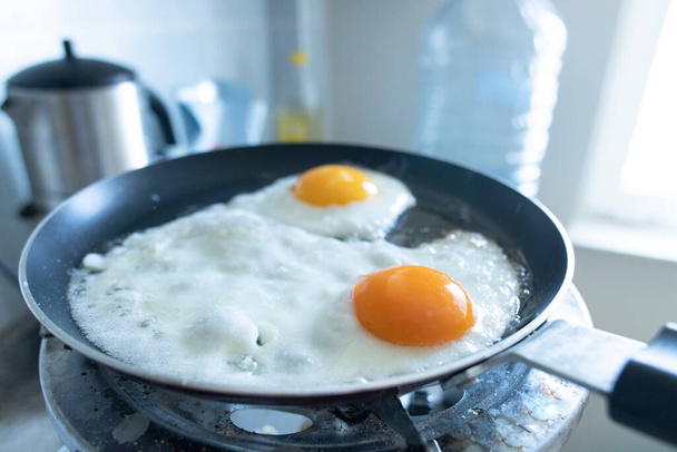 Tavada iki çırpılmış yumurta. Gaz silindirinde.. - Fotoğraf, Görsel
