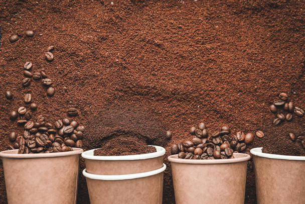 Паперові чашки та кавові зерна на порошку
 - Фото, зображення