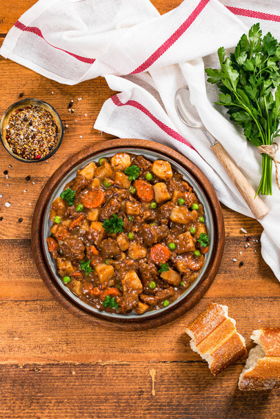 Μοσχάρι Curry Stew με πατάτες και καρότα σε ξύλινο φόντο. Επιλεκτική εστίαση. - Φωτογραφία, εικόνα