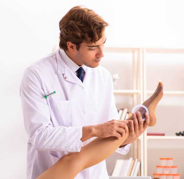 Médico masculino verificando a flexibilidade articular com goniômetro
 - Foto, Imagem