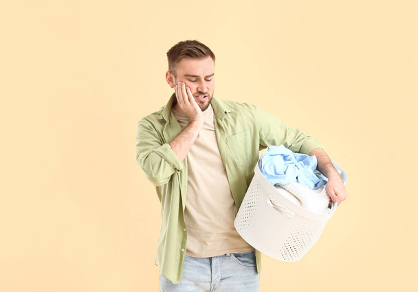 Troubled man with laundry on color background - Photo, Image