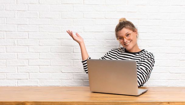 young pretty latin woman smiling proudly and confidently, feeling happy and satisfied and showing a concept on copy space sitting with her laptop - Foto, Imagen