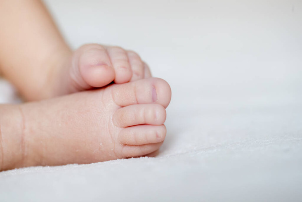 νεογέννητο πόδι ξαπλωμένο στο πλάι με επιλεκτική εστίαση - Φωτογραφία, εικόνα