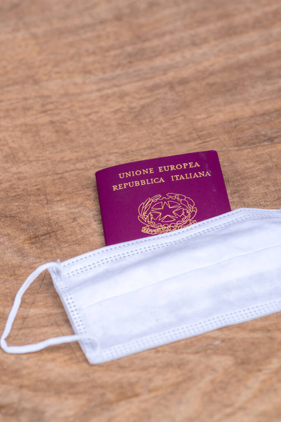İtalyan pasaportu ve sağlık maskesi. Coronavirüs salgını veya covid-19 salgını sırasında seyahat kısıtlamaları ve karantina kavramının uygulanması - Fotoğraf, Görsel