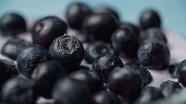 Close up of bog whortleberries in yogurt rotating in slow motion. Macro view of ripe blueberries in yoghurt. - Materiał filmowy, wideo