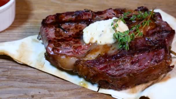Egy kesztyűs pincér felvágja a szaftos steaket. Éttermi séf szeletelés közepes ritka marhahús steak. - Felvétel, videó