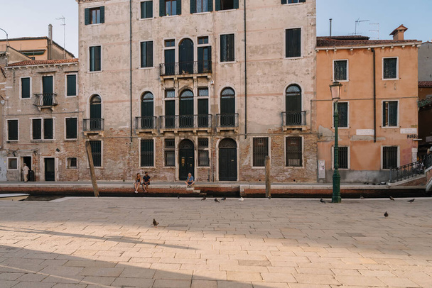 Venice, Italy - August 13, 2016: Tourists are resting by the canal of Venice, Italy. - 写真・画像